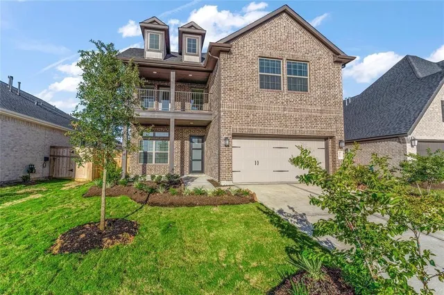 a front view of a house with a garden and plants