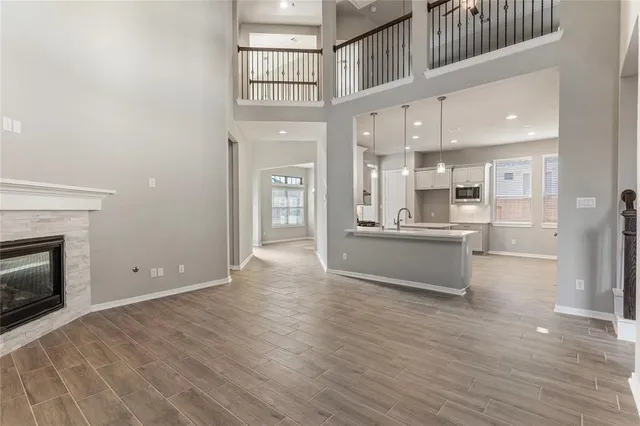 a view of kitchen with kitchen island wooden floor and stainless steel appliances