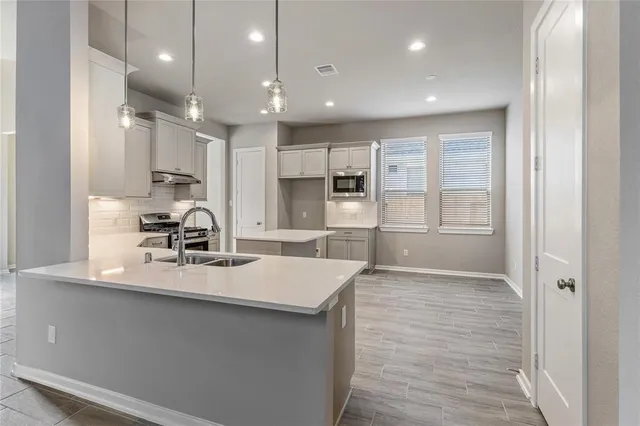 a large kitchen with kitchen island a sink stainless steel appliances and cabinets