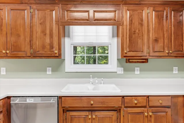 a view of an empty room with cabinet and a window