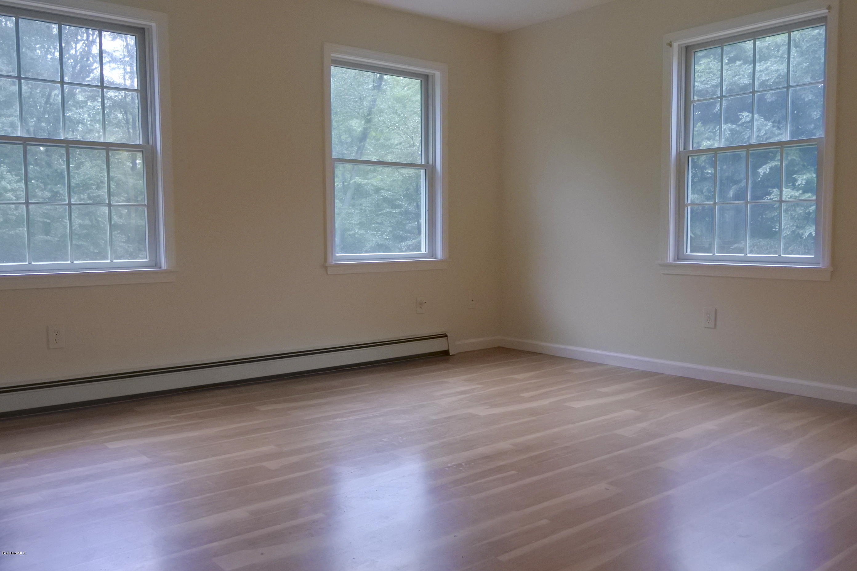 24 Housatonnuck Road Stockbridge, MA 01262 - Photo 13 of 36 an empty room with wooden floor and windows