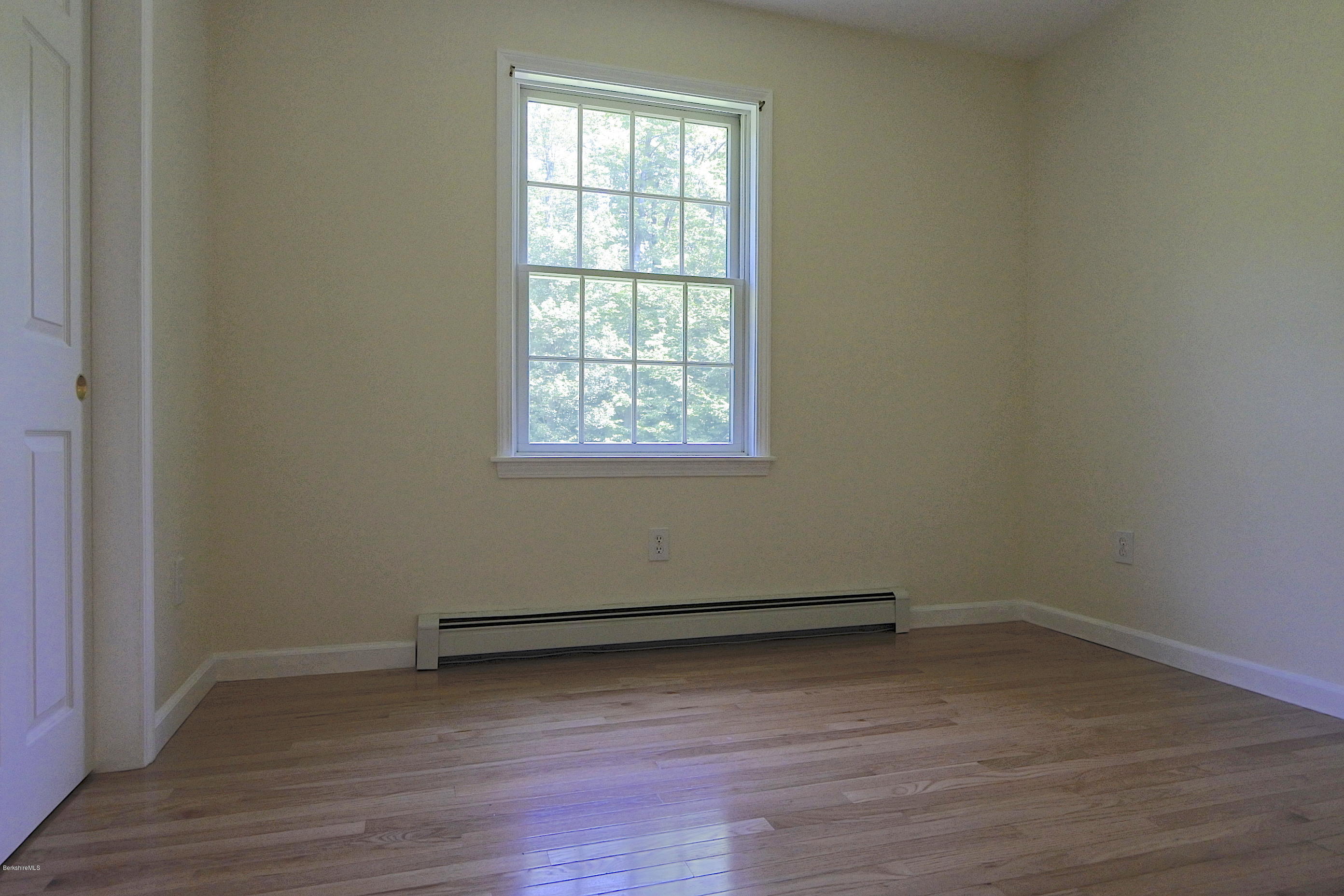 24 Housatonnuck Road Stockbridge, MA 01262 - Photo 21 of 36 an empty room with wooden floor and windows