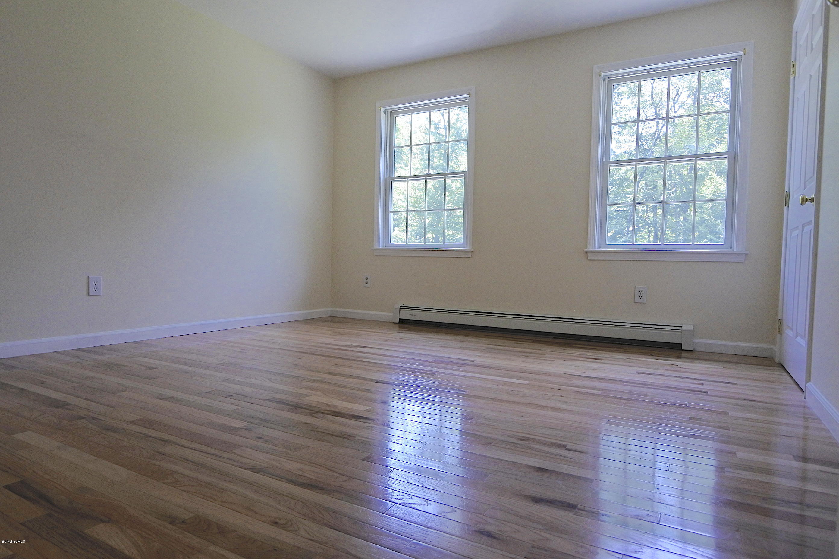 24 Housatonnuck Road Stockbridge, MA 01262 - Photo 22 of 36 an empty room with wooden floor and windows