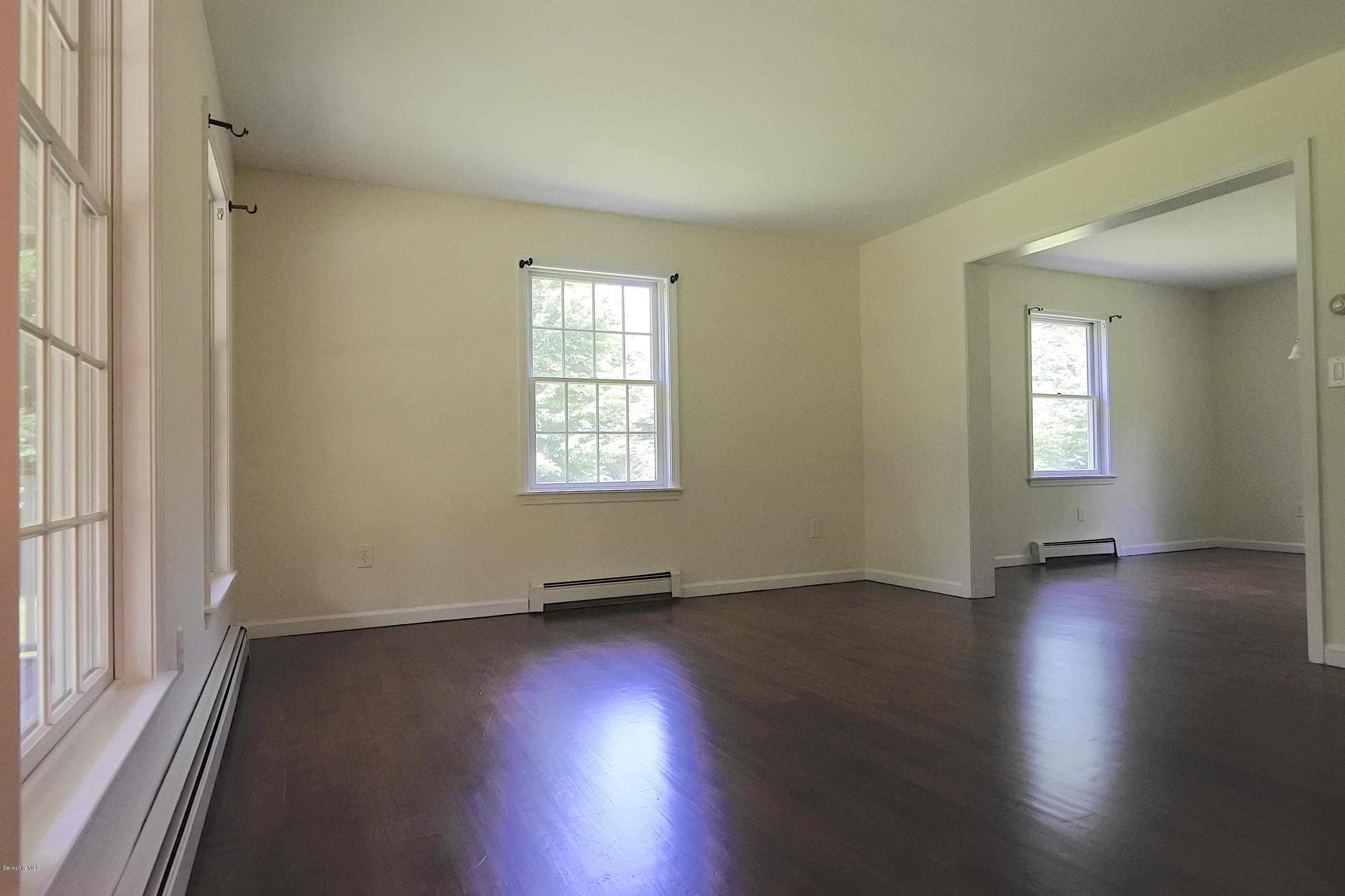 24 Housatonnuck Road Stockbridge, MA 01262 - Photo 9 of 36 an empty room with wooden floor and windows