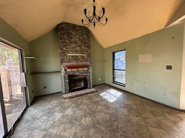 a view of an empty room with a fireplace and a window
