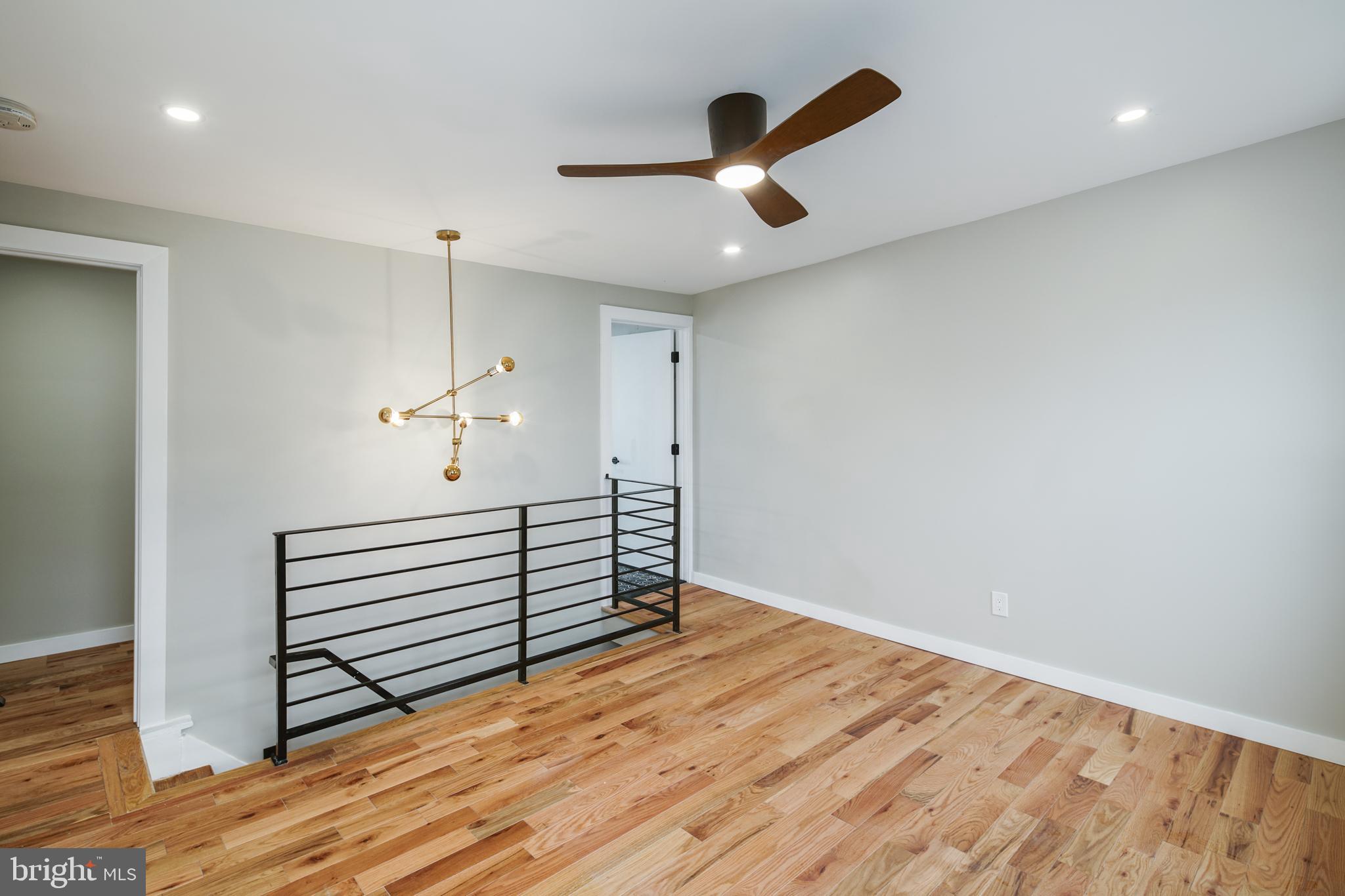 1129 South 12th Street Philadelphia, PA 19147 - Photo 21 of 24 an empty room with wooden floor chandelier fan and windows