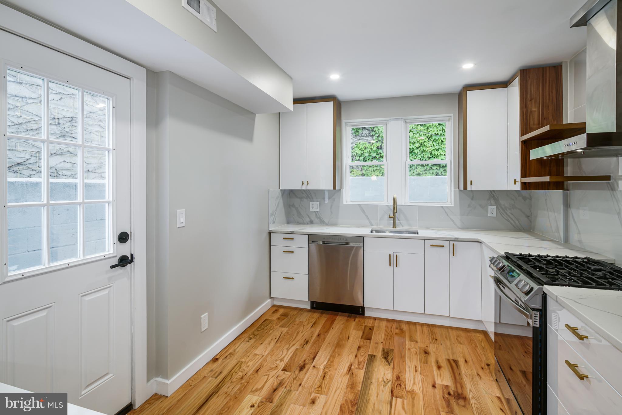 1129 South 12th Street Philadelphia, PA 19147 - Photo 9 of 24 a kitchen with a sink window and cabinets