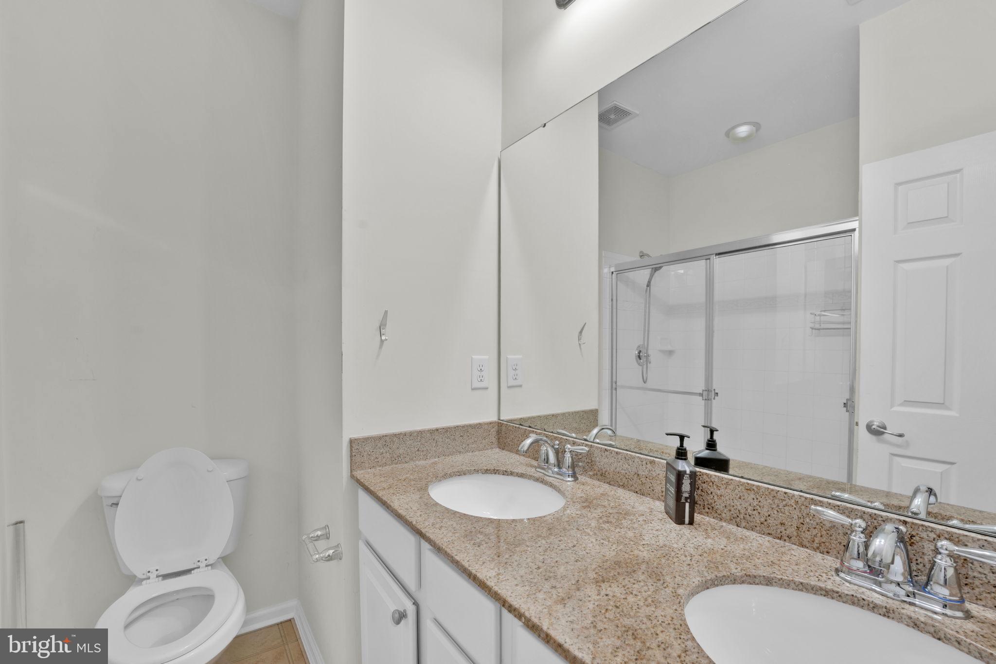 7138 Station House Road Elkridge, MD 21075 - Photo 16 of 42 a bathroom with a granite countertop sink toilet and mirror