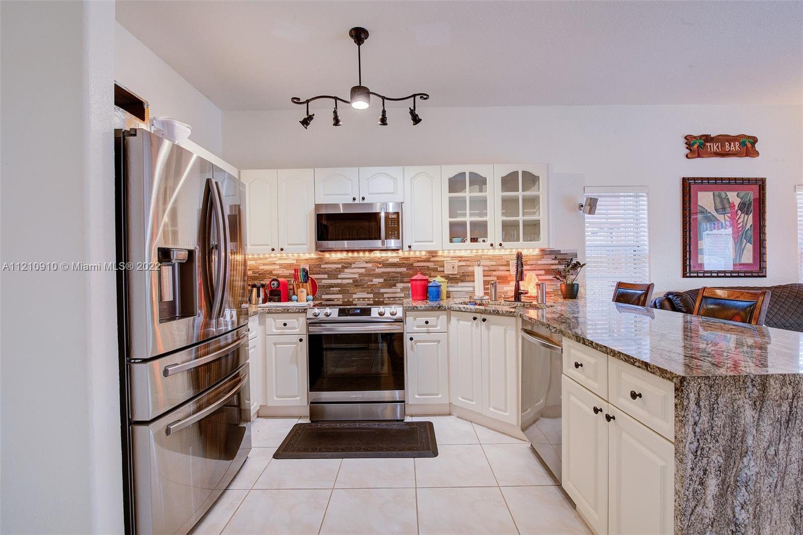 18226 Southwest 145th Avenue Miami, FL 33177 - Photo 12 of 30 a kitchen with stainless steel appliances a stove refrigerator sink and microwave