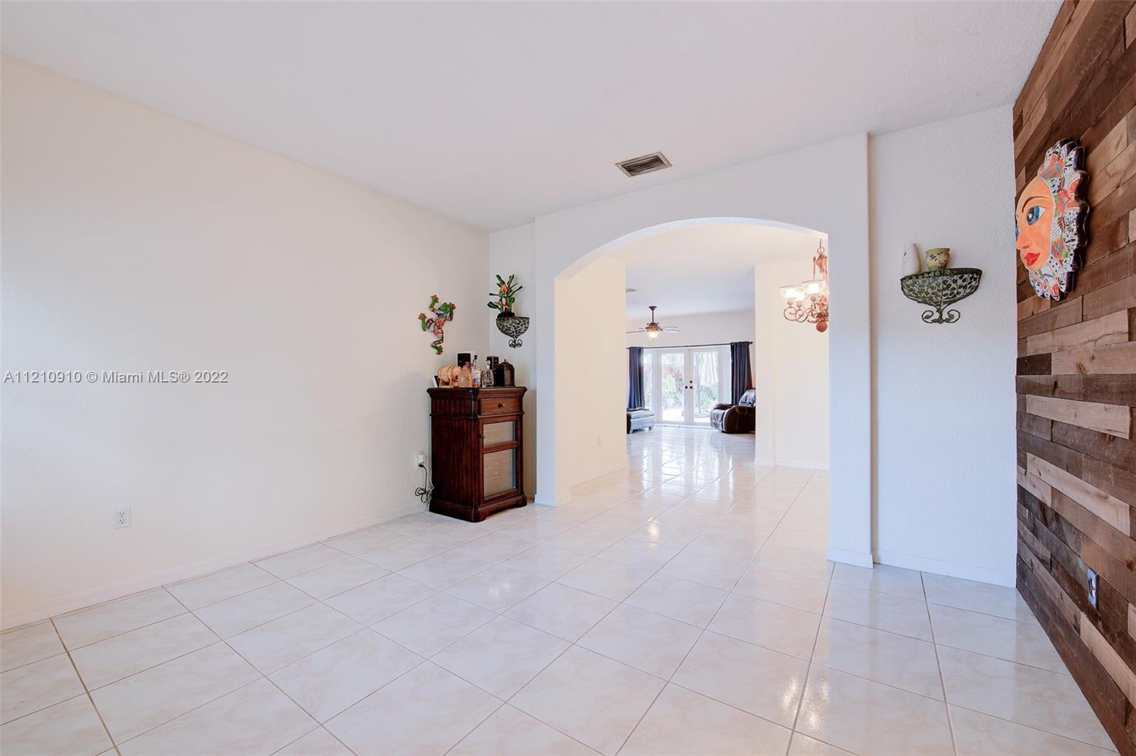 18226 Southwest 145th Avenue Miami, FL 33177 - Photo 4 of 30 a view of a hallway with dining area and chandelier