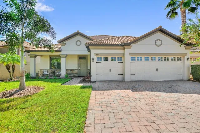 a view of a white house with a yard and potted plants
