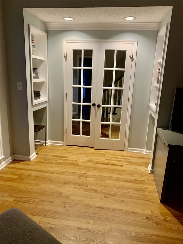 8512 Wheeling Drive Raleigh, NC 27615 - Photo 19 of 30 Built-in shelving and glass, French doors in the front office/study area. Studio/Study/Office