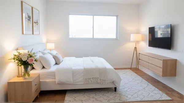 a bedroom with a bed and a flat screen tv