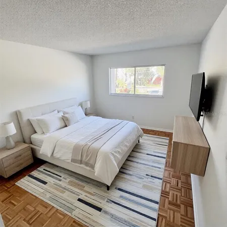 a bedroom with a bed and flat screen tv