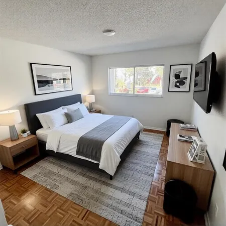 a bedroom with a bed a mirror and a window