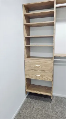 a view of walk in closet with empty racks
