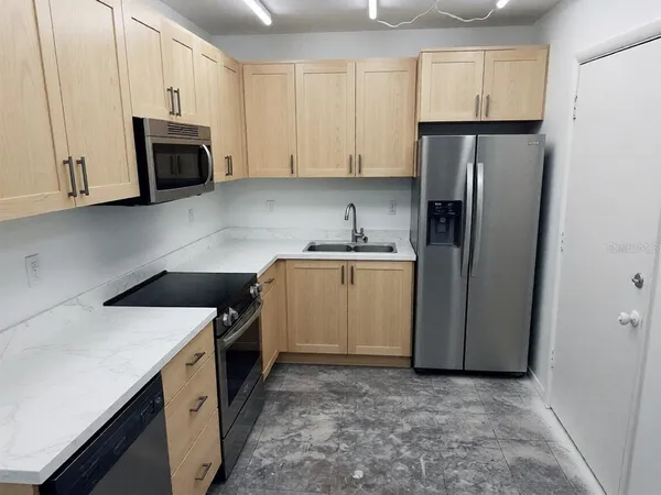 a kitchen with a sink a refrigerator and cabinets