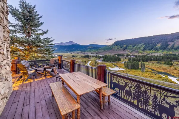a view of a balcony with wooden floor and outdoor seating