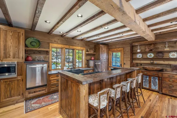 a kitchen with stainless steel appliances granite countertop a stove a sink dishwasher and cabinets with wooden floor