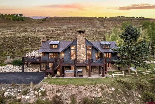 a view of a big house with a big yard and large trees
