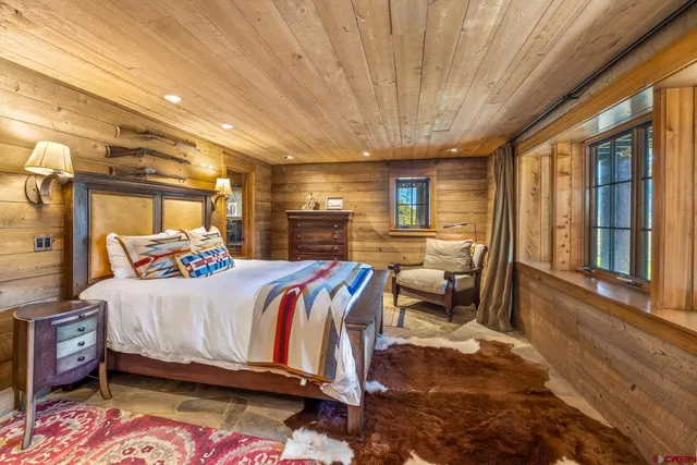 a bedroom with furniture and a large window