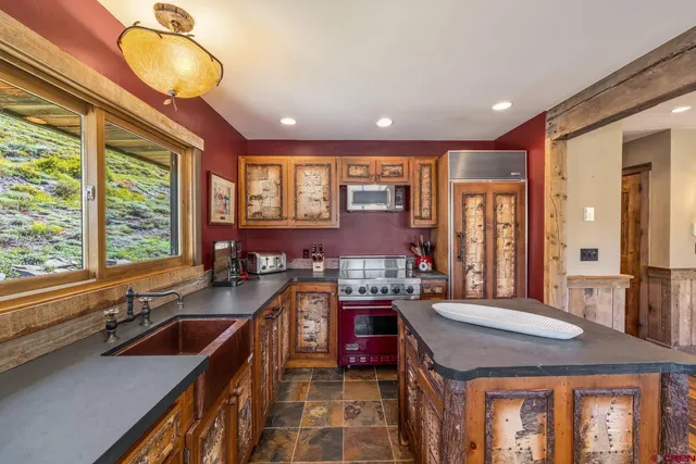 a kitchen with stainless steel appliances granite countertop a stove a sink and a refrigerator