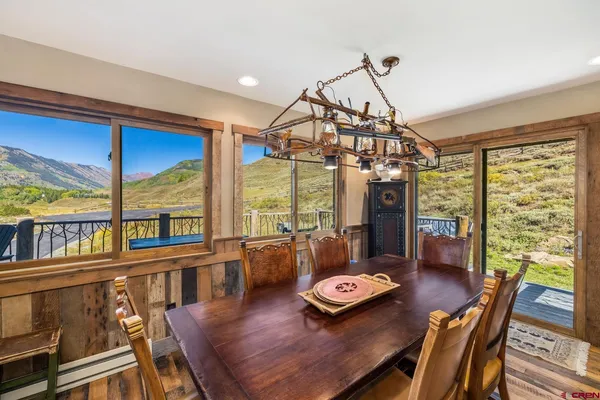 a living room with furniture a large window and wooden floor