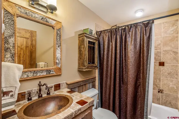 a bathroom with a sink a toilet and a mirror