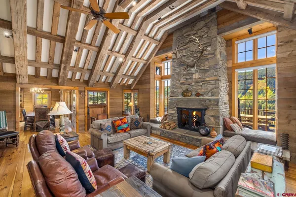 a living room with furniture a fireplace and a floor to ceiling window
