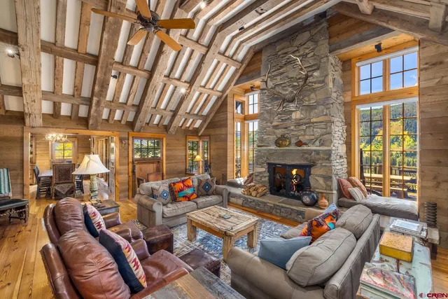 a living room with furniture a fireplace and a floor to ceiling window