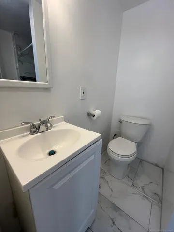 a bathroom with a sink a toilet and mirror