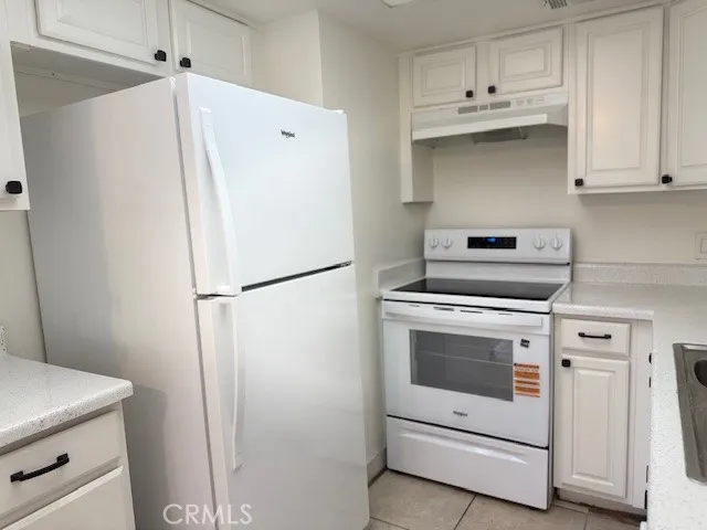 a kitchen with white cabinets and white appliances