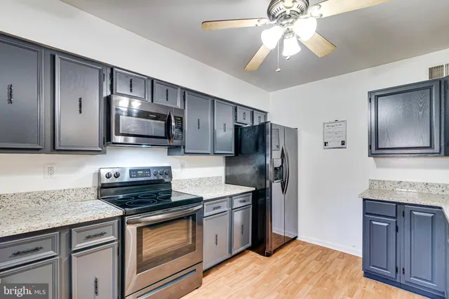 a kitchen with stainless steel appliances granite countertop a stove refrigerator and microwave