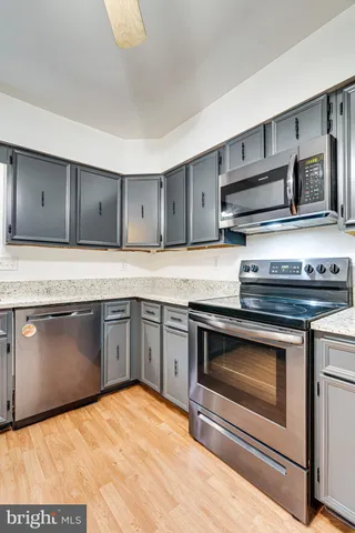 a kitchen with granite countertop stainless steel appliances and wooden cabinets