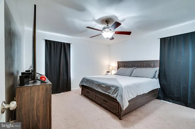 a spacious bedroom with a bed and a chandelier