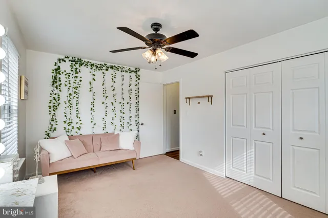 a living room with furniture and a ceiling fan