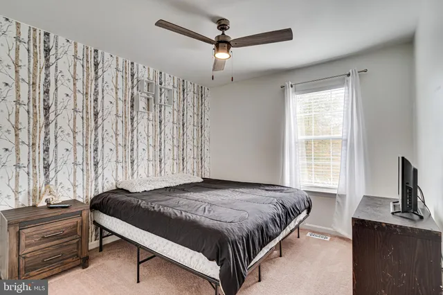 a bedroom with a bed next to a window with a chandelier