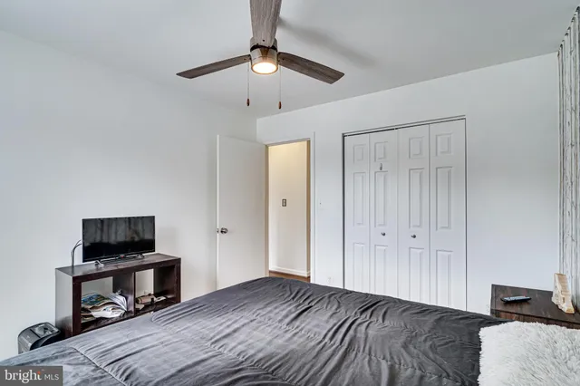 a bedroom with a bed and a flat tv screen on a dresser