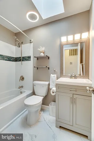 a bathroom with a granite countertop toilet a sink and a mirror