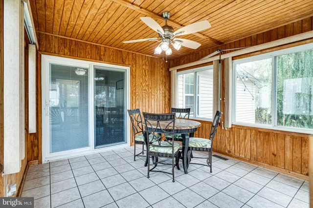 a dining room with furniture and large windows