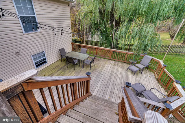a balcony with wooden floor table and chairs