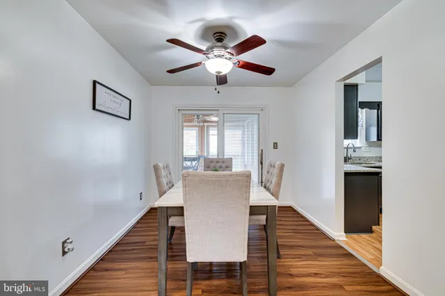 a dining room with wooden floor a chandelier a wooden table and chairs