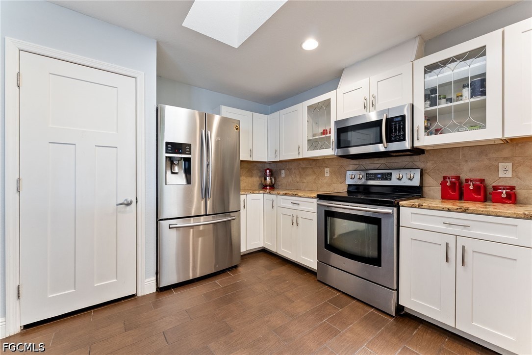 17290 Rewis Road Alva, FL 33920 - Photo 12 of 50 a kitchen with stainless steel appliances granite countertop a refrigerator and a stove top oven