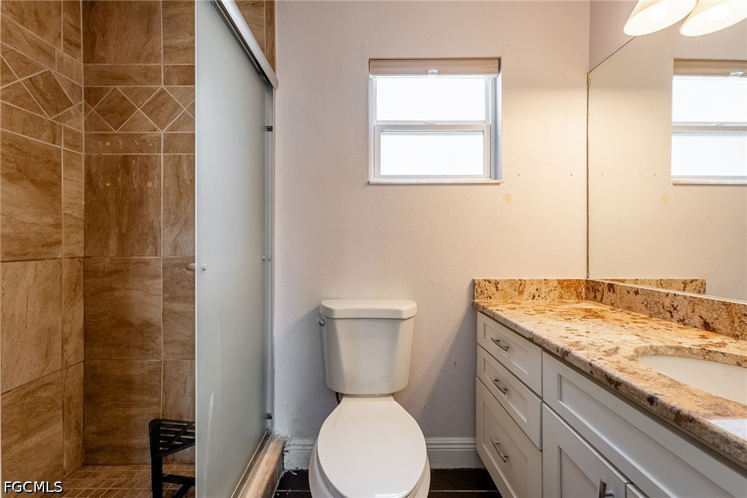17290 Rewis Road Alva, FL 33920 - Photo 16 of 50 a bathroom with a granite countertop toilet a sink and a mirror