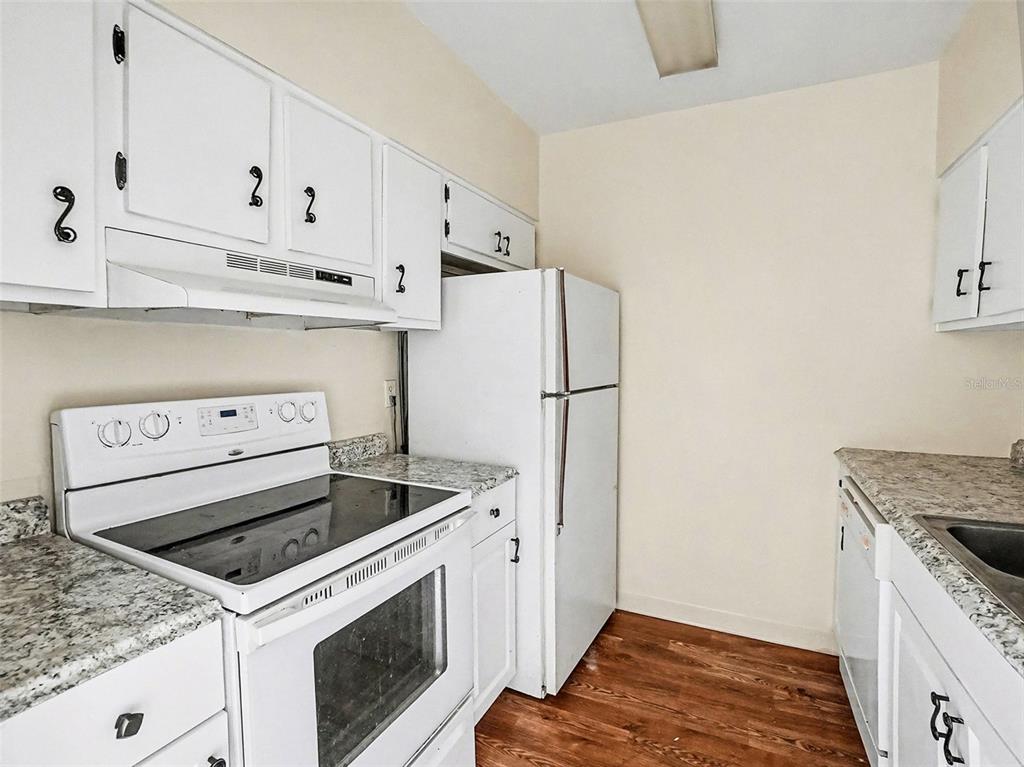 2500 Lee Road, Unit 237 Winter Park, FL 32789 - Photo 11 of 23 a kitchen with white cabinets and white appliances