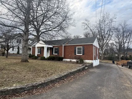 a view of a yard in front of a house with large tree