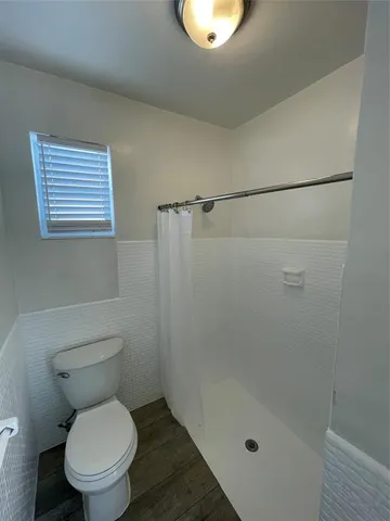 a bathroom with a toilet and a shower