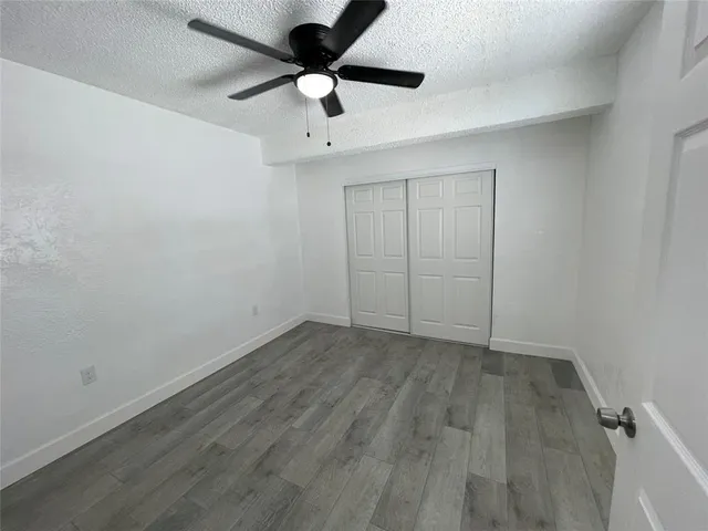 an empty room with a ceiling fan and carpet