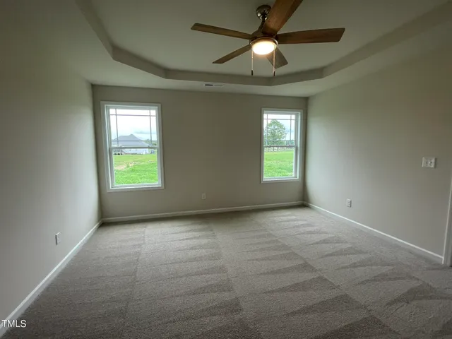 an empty room with windows and fan