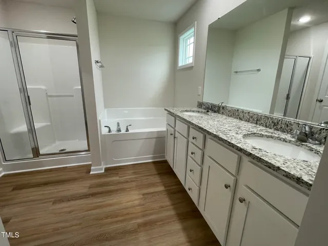 a bathroom with a granite countertop sink mirror and a bathtub